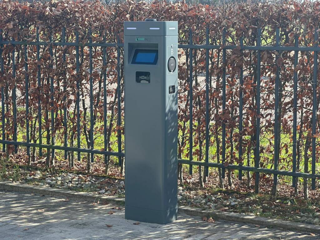Laadpaal van Charge Zone naast een tuinhek